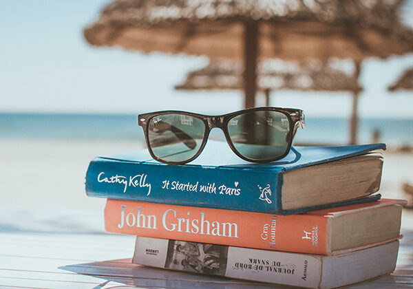Three books stacked at the beach